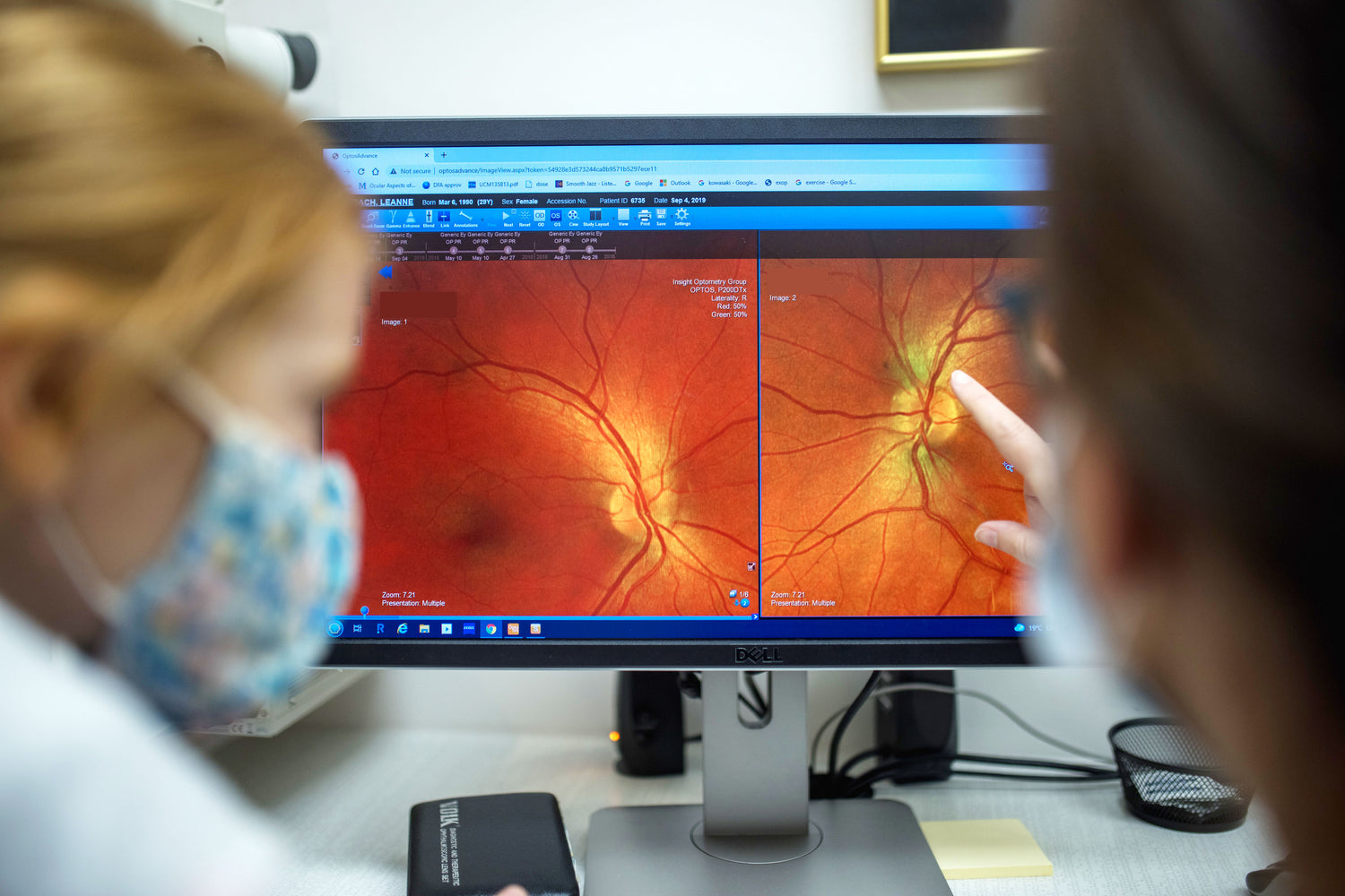 Close up of a child and an adult are looking a computer screen that has a photo of a retina.