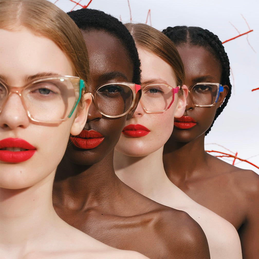 Close up. Line up of four women of different skin tones, each wearing a different brightly coloured pair of Etnia eyeglasses.