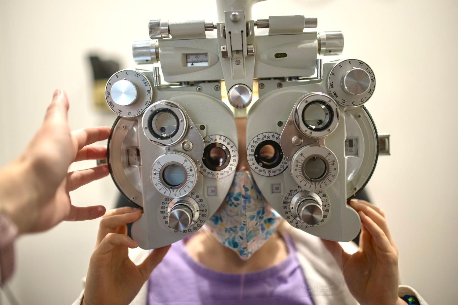 Close up of a child holding up large eyeglass equipment, having presription measured.