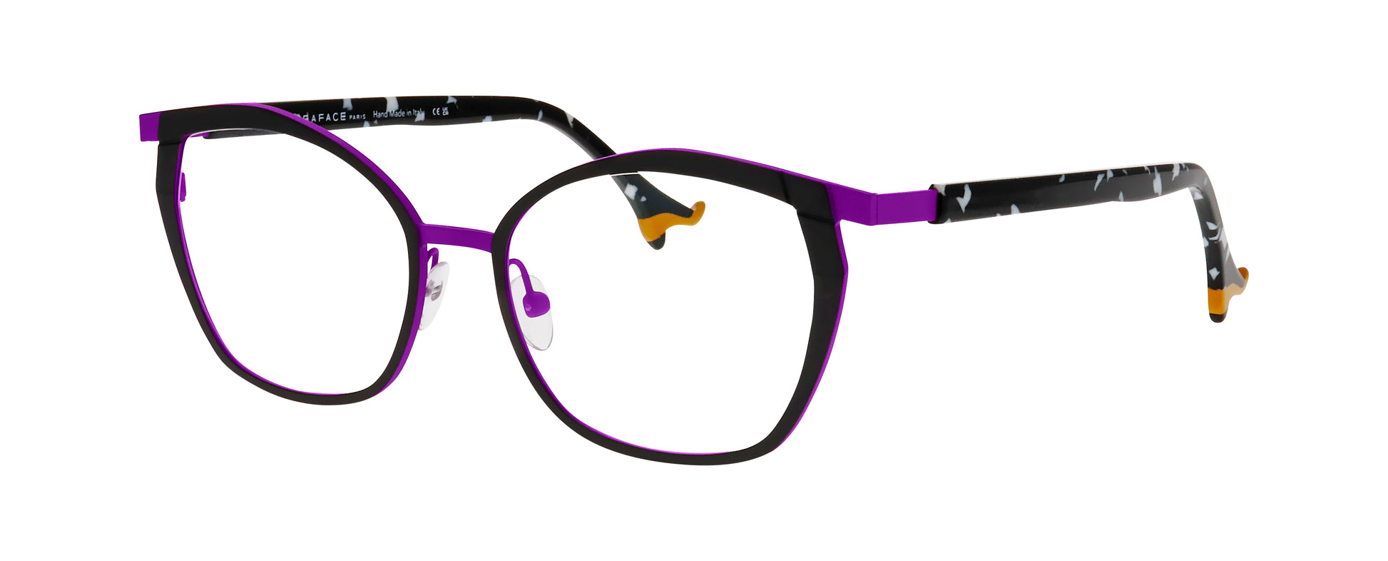 Women's prescription eyewear – A partial side view of an oval titanium frame that is black and purple in colour.  The black and white speckled temples are finished with orange ladies’ shoe tips